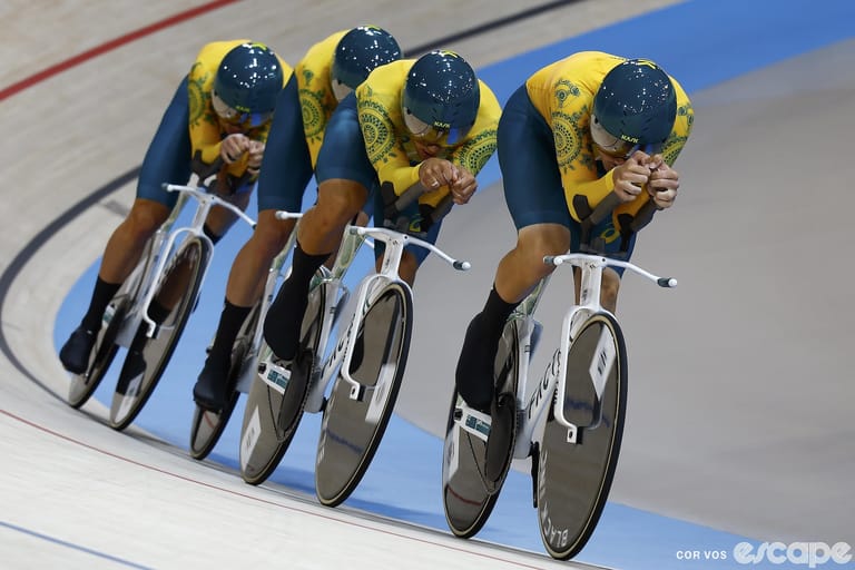 The Australian men's Team Pursuit squad races in the gold medal final. They are a tight paceline of four coming out of one of