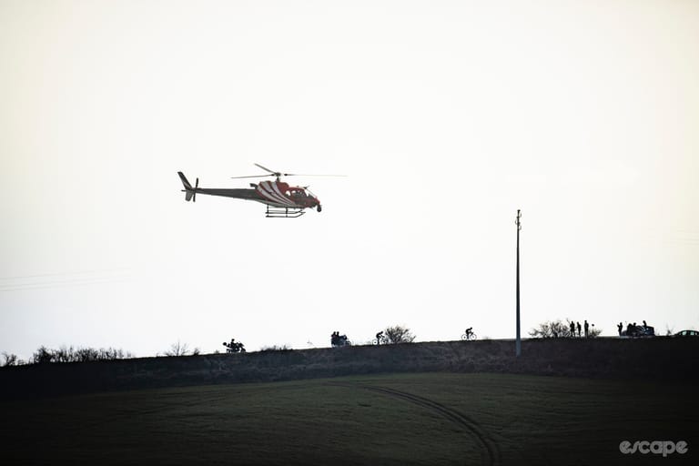 A TV helicopter hovers over a pack of racers.